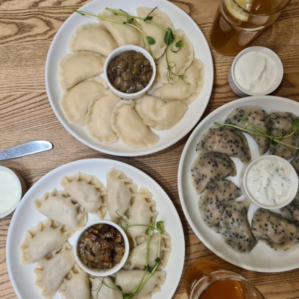 Mehrere Teller mit verschiedenen Sorten von Pierogi