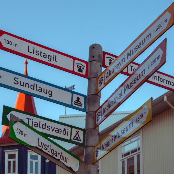 Blick auf ein Straßenschild in Akureyri, das unter anderem auf das Akureyri Museum zeigt